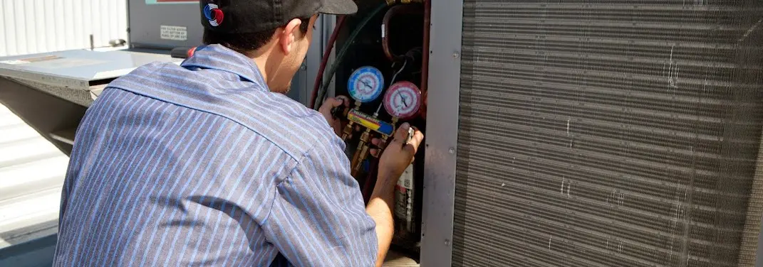 HVAC technician servicing a condenser unit in Lakeport