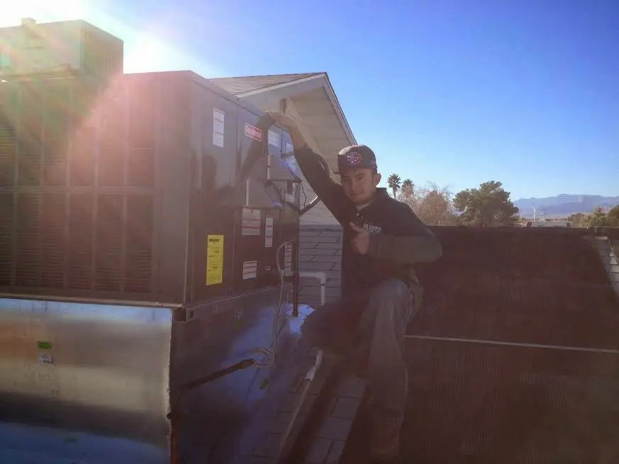HVAC technician performing Air Duct Cleaning on a rooftop unit in Lakeport